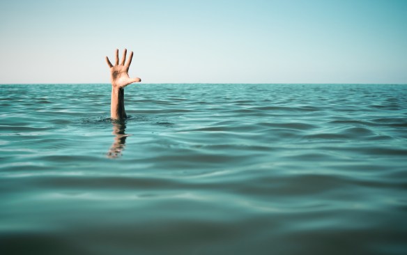 Hand in sea water asking for help. Failure and rescue concept.